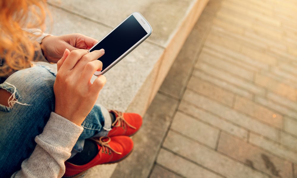 Woman on her phone being accepted for a quick £100 loan