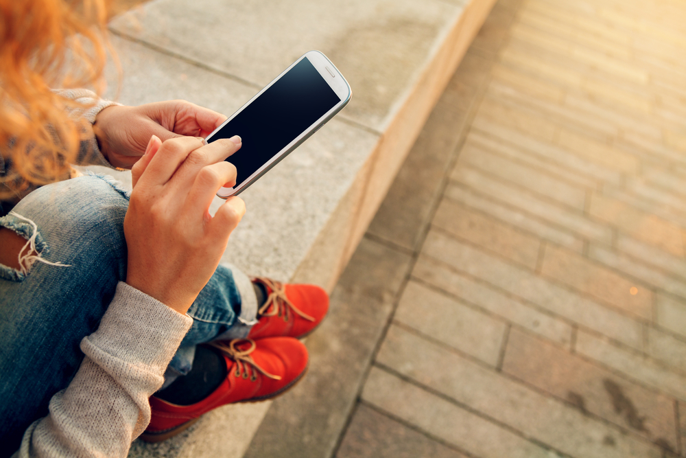 Woman on her phone being accepted for a quick £100 loan